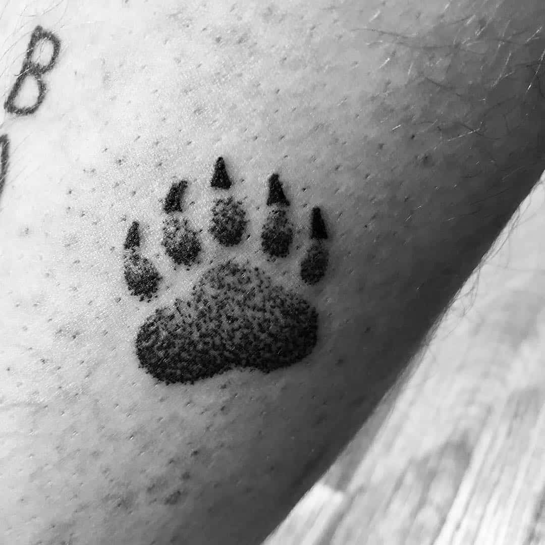 A striking bear paw tattoo on a forearm, capturing the essence of the wild