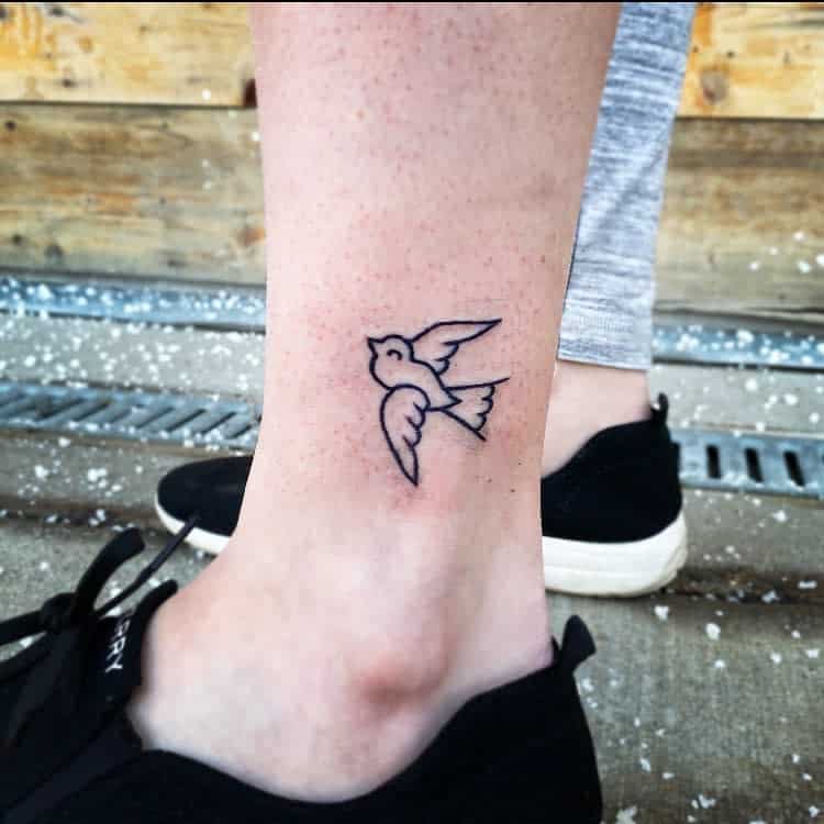Minimalist swallow tattoo on an ankle