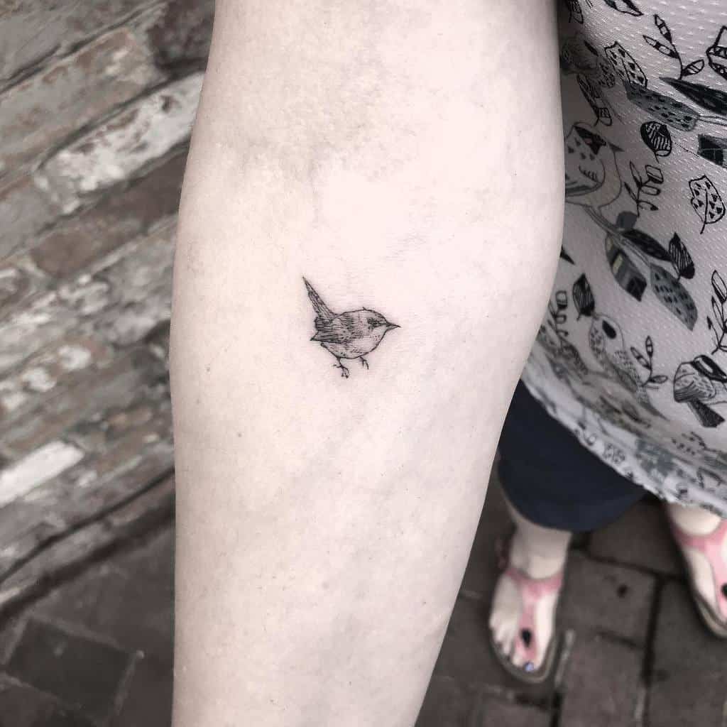 Small bird tattoo on forearm
