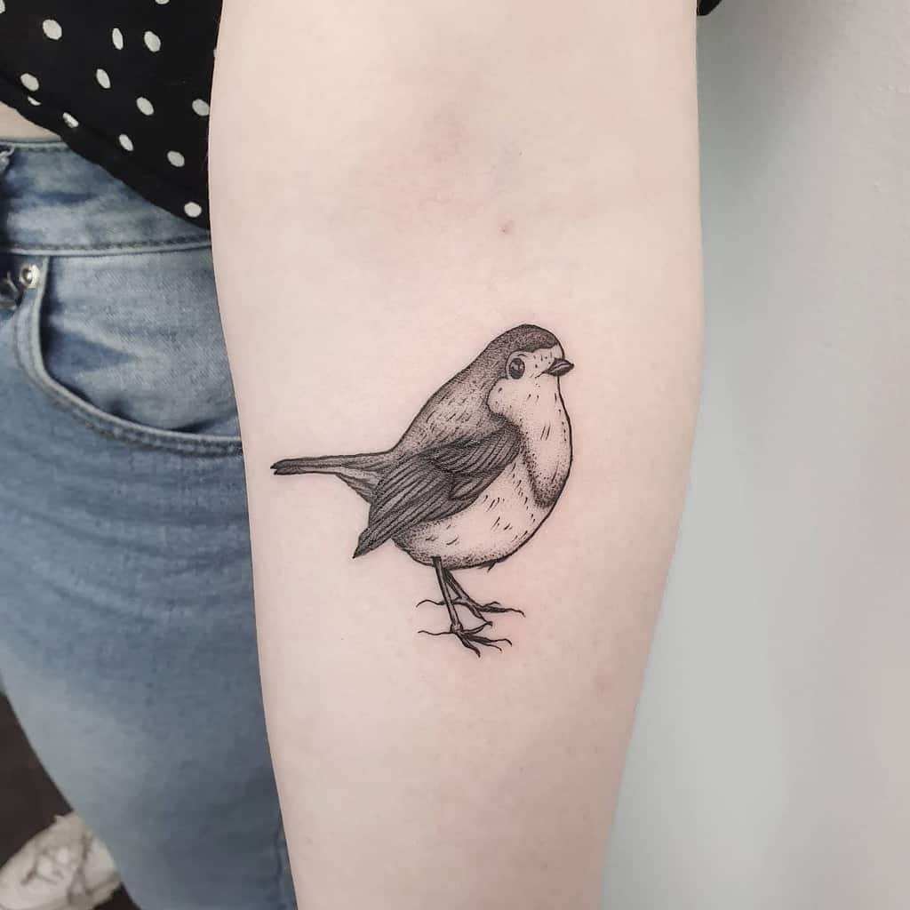 Forearm tattoo of a small sparrow in black and gray ink