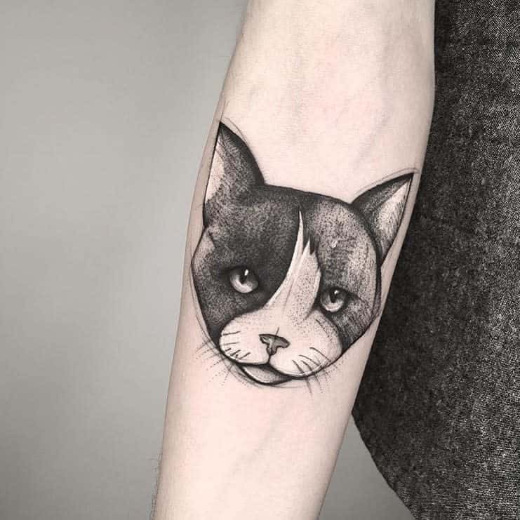 A tattoo of a cat's face on a forearm