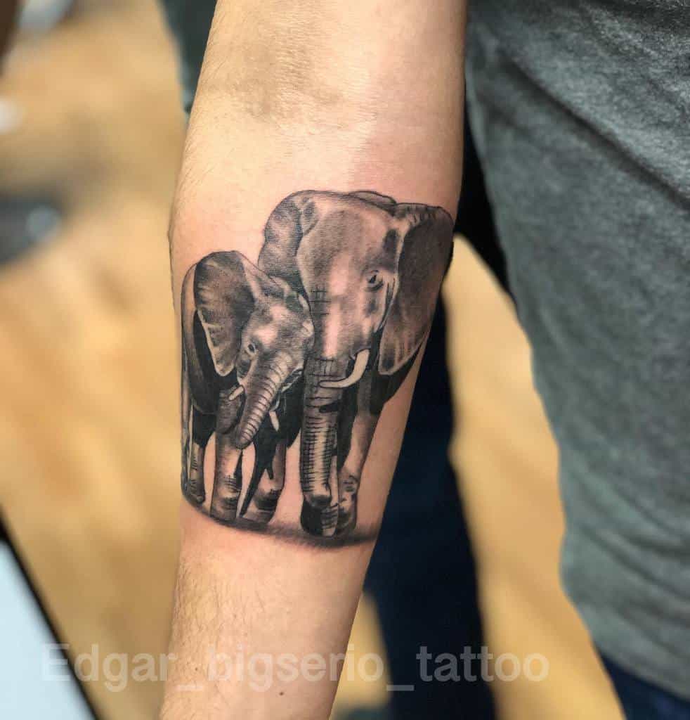 Tattoo of two elephants, one large and one small, on a forearm