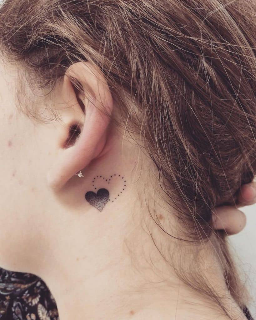 Delicate black heart tattoo, featuring a shaded design with a dotted outline of a second heart