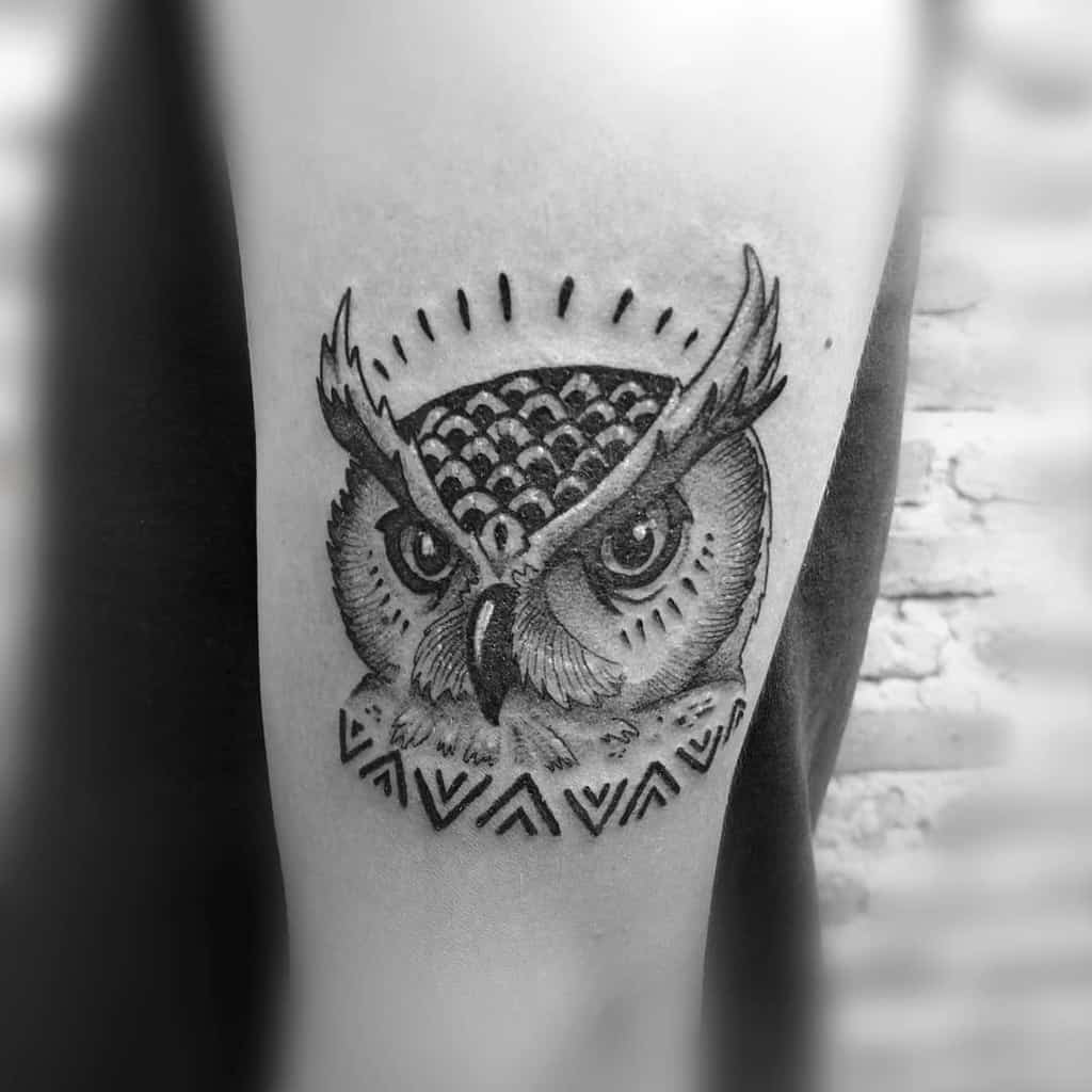 An intricately designed black and white owl tattoo with mesmerizing geometric patterns adorns the arm