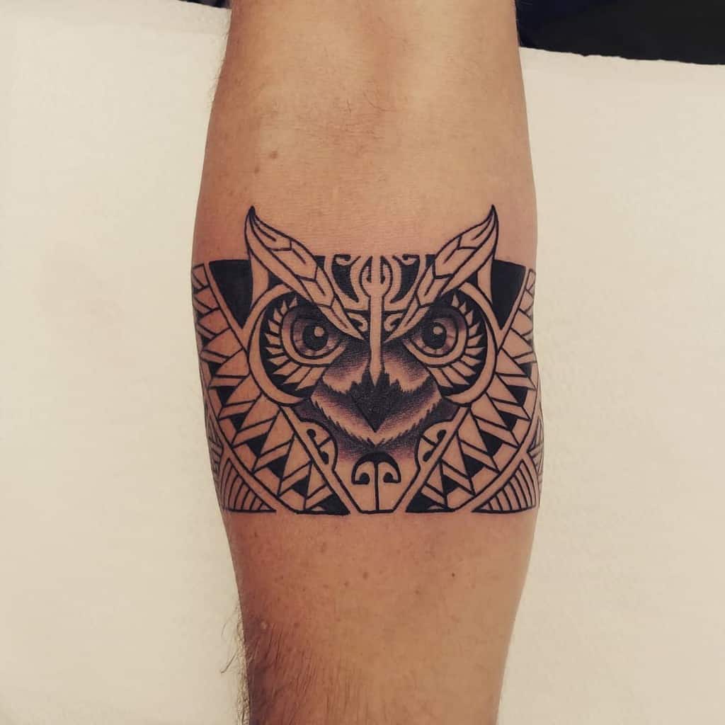 Geometric owl tattoo gracefully adorns an arm, showcasing intricate patterns and bold lines