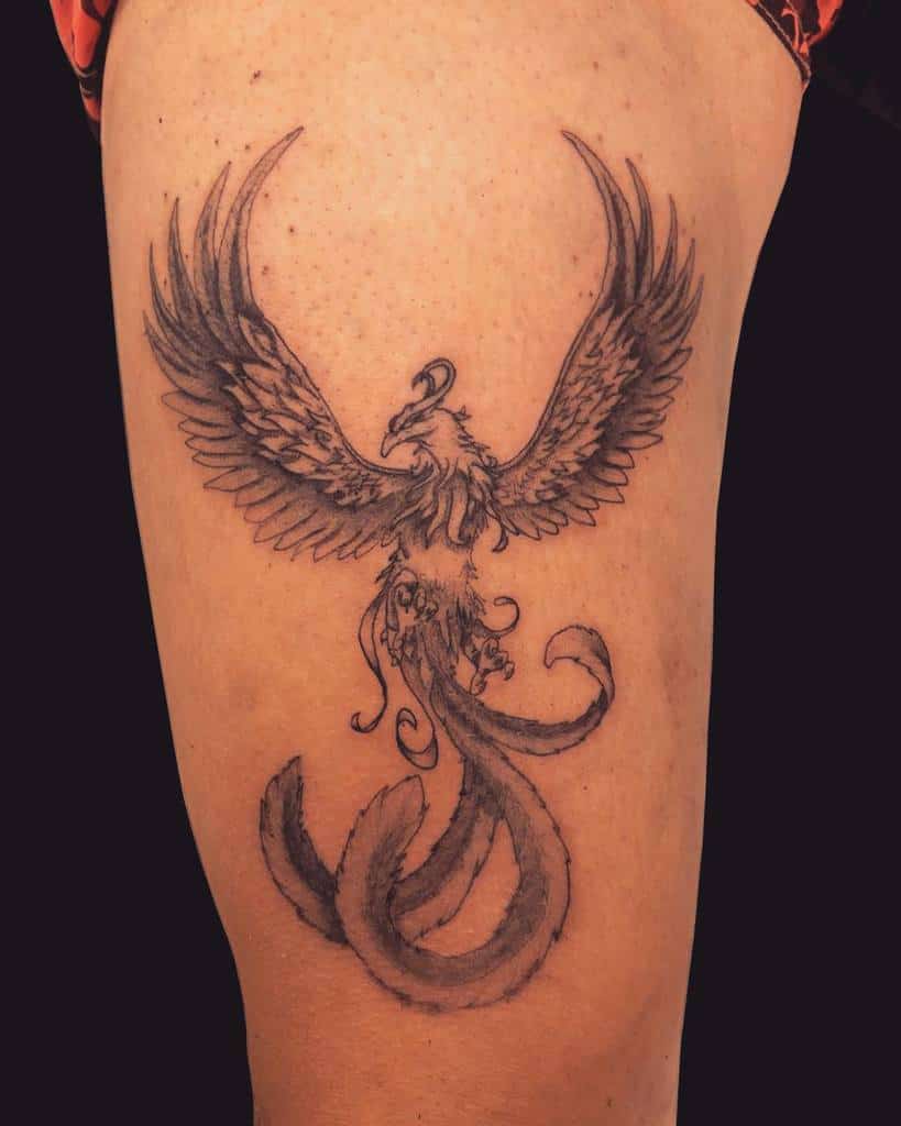 Tattoo of a phoenix with outstretched wings on a thigh
