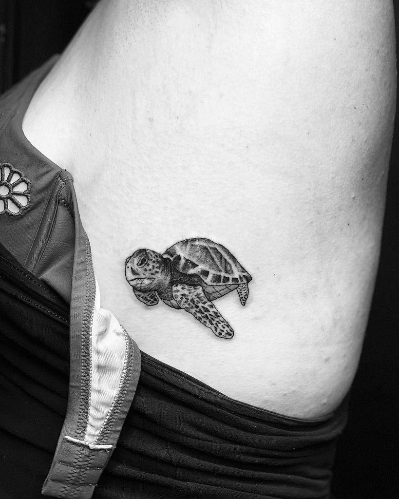 Black and white tattoo of a sea turtle on a side