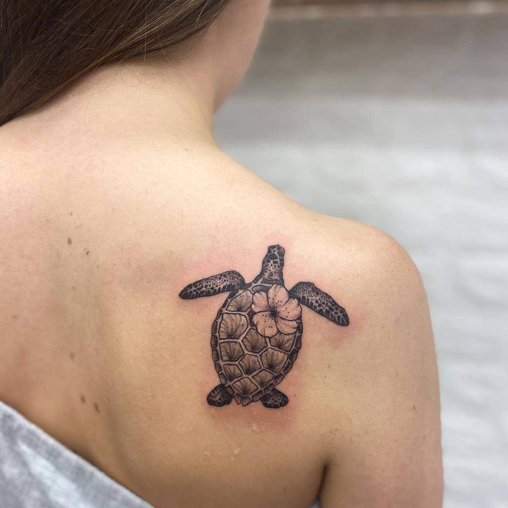 A sea turtle tattoo on a woman's shoulder