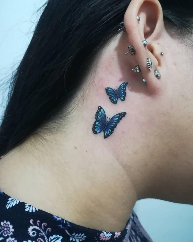 Two blue butterflies tattooed behind the ear