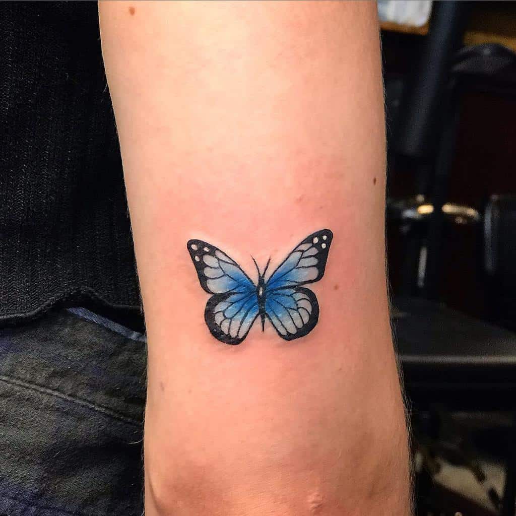 Tattoo of a stunning blue butterfly with black accents