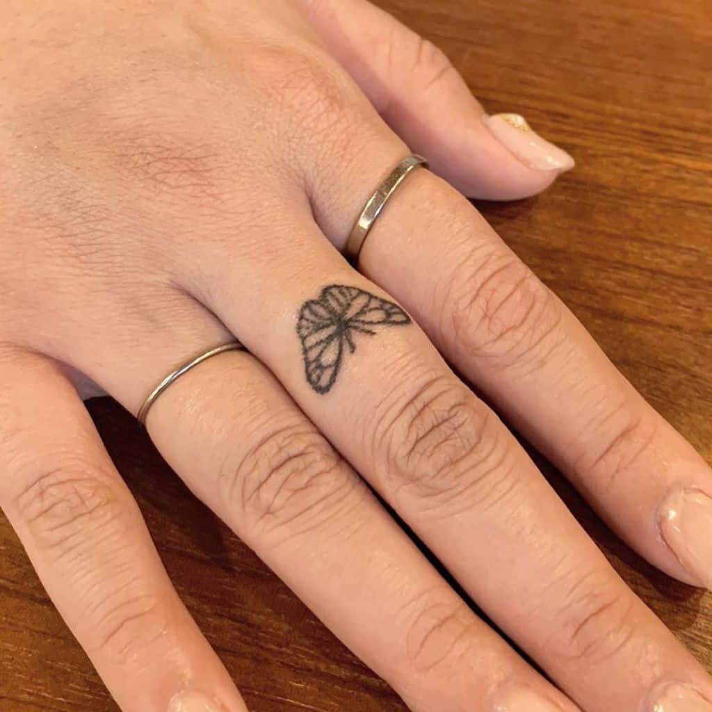 A small delicate butterfly tattoo on the finger