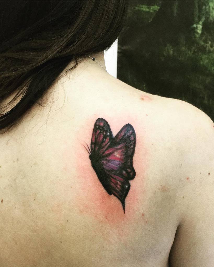 A delicate butterfly tattoo graces the person's shoulder