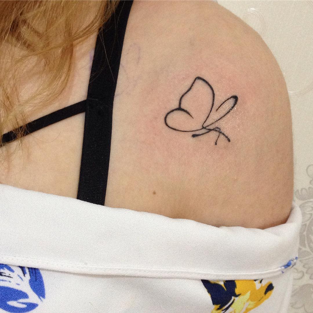 Minimalist butterfly tattoo on the shoulder, featuring clean black linework for a simple and elegant design