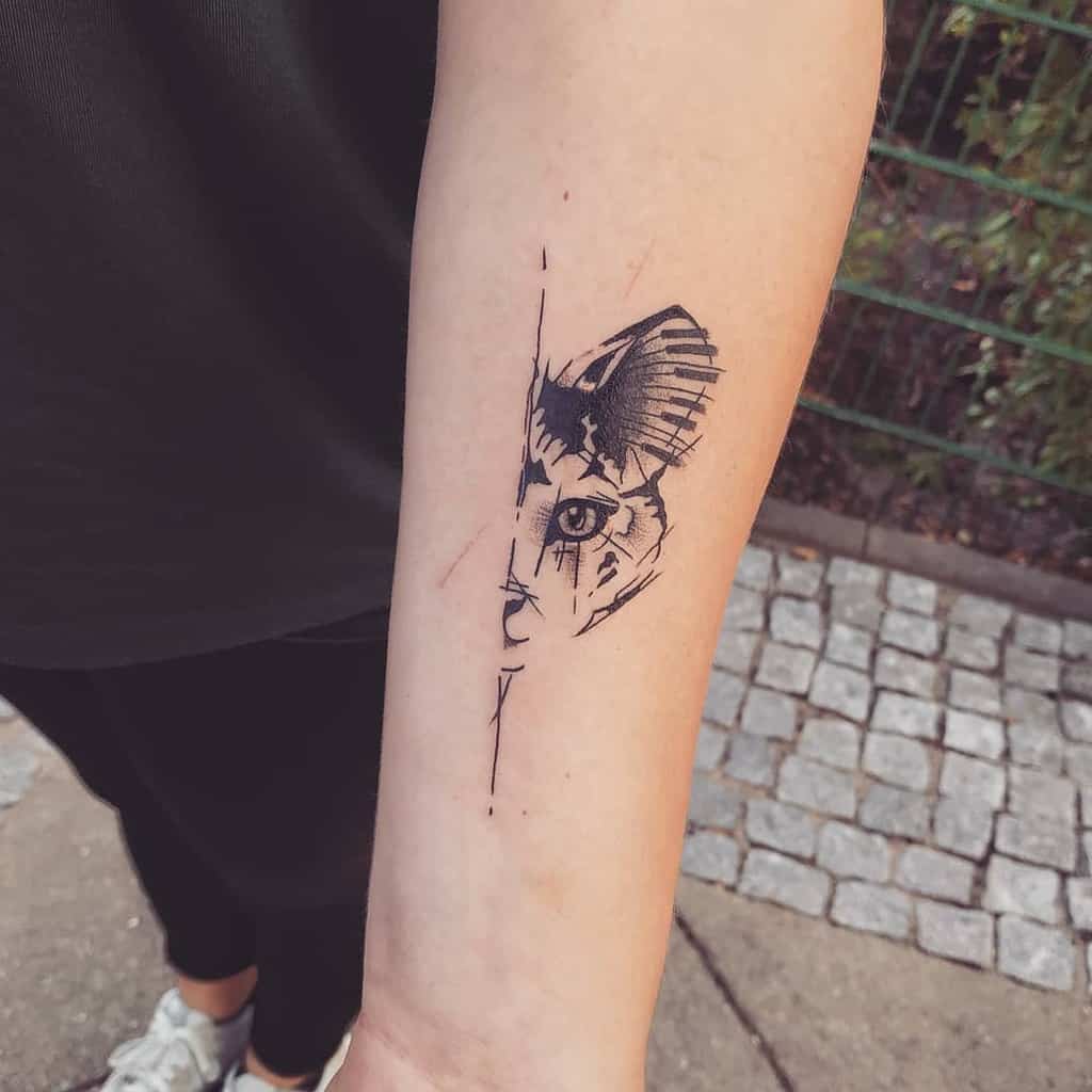 Forearm tattoo of a stylized half cat face with geometric lines