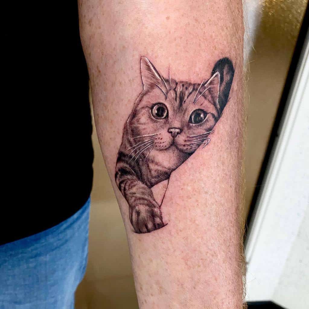 A realistic cat tattoo on an arm