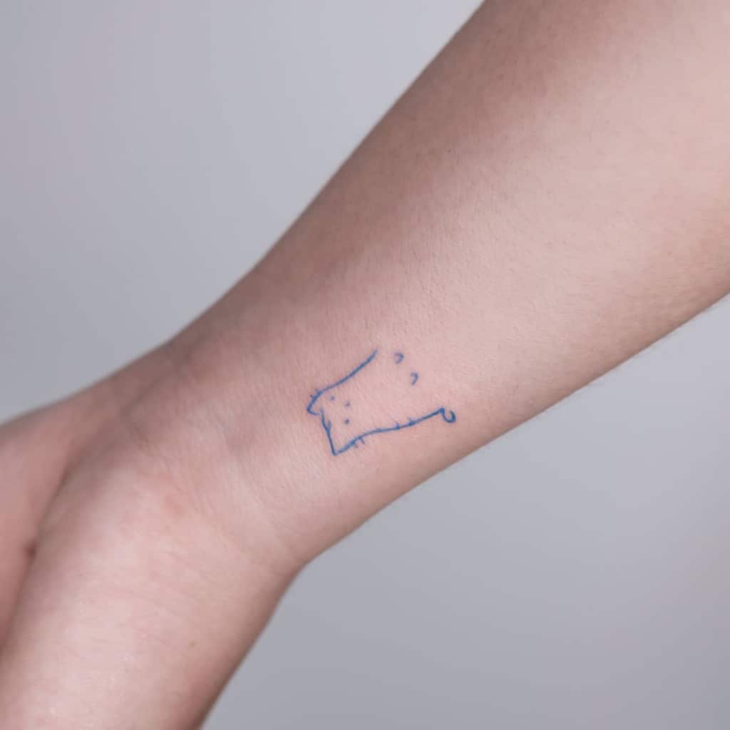Simple outline tattoo of a cat's face on a person's inner wrist