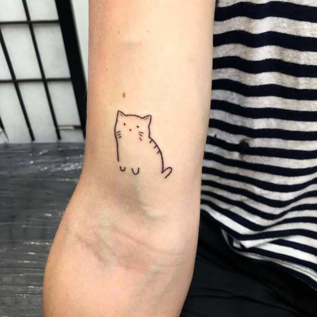 Simple cat tattoo on the inner arm near the elbow