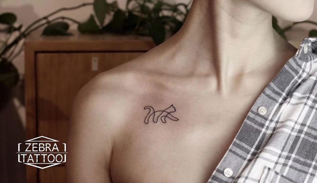 Outline tattoo of a striding cat on the chest