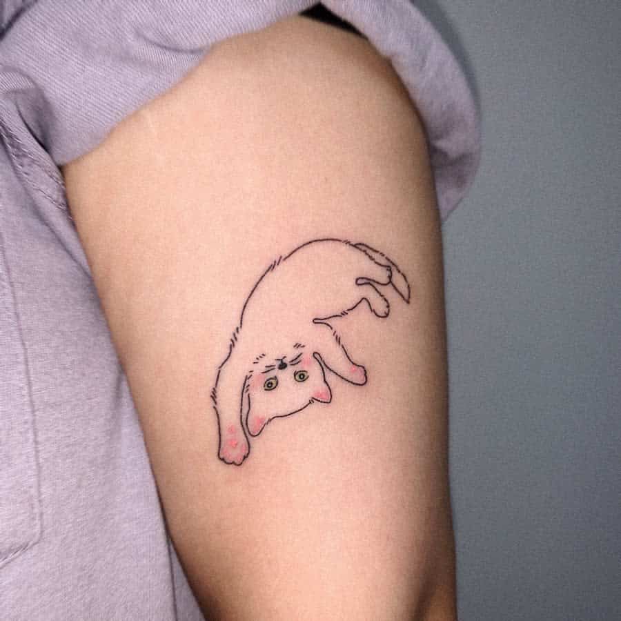 Cartoon cat tattoo on inner arm, with pink ears and an upside-down playful pose