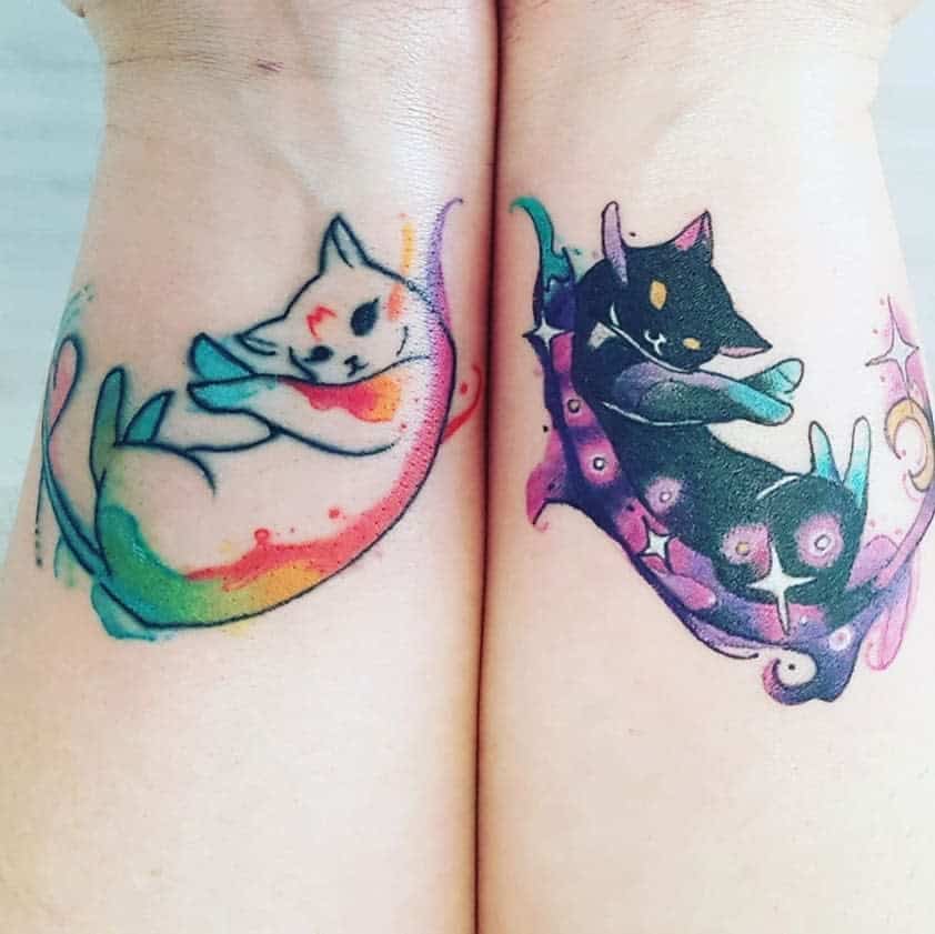 Colorful cat tattoos with swirling patterns on forearms