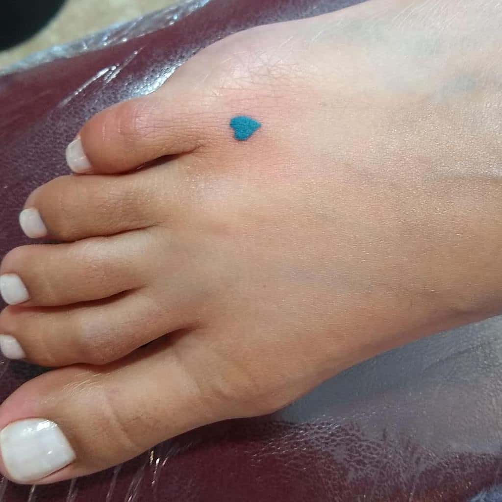 Foot with blue heart tattoo on toe