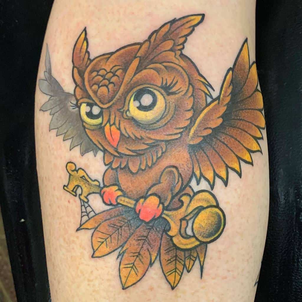 A vibrant owl tattoo clutches a key, its detailed feathers and expressive eyes radiating wisdom