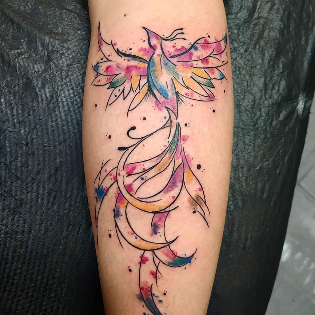 Colorful phoenix tattoo with abstract design on forearm featuring watercolor-like splashes