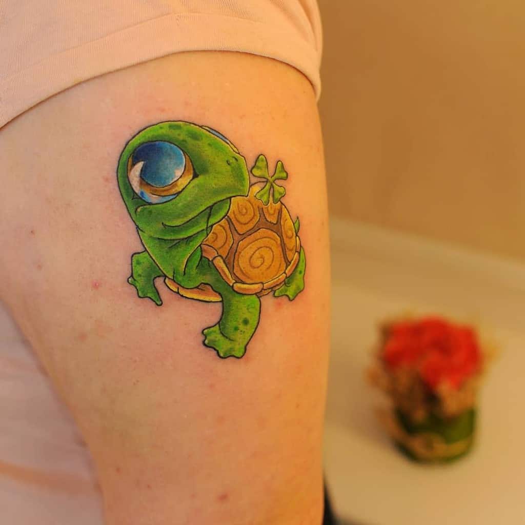 A cartoon turtle tattoo on an upper arm