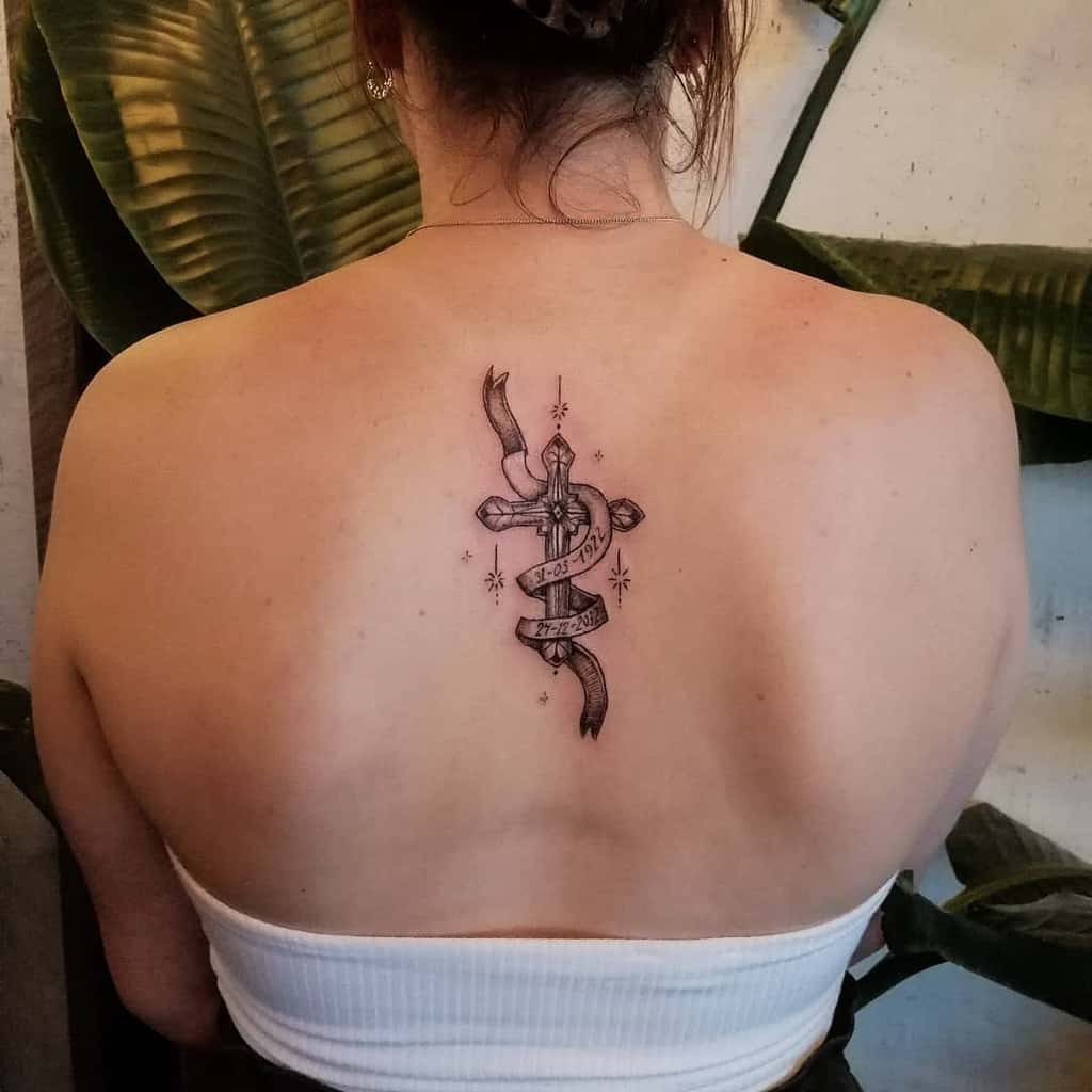 Woman with sword and ribbon tattoo on her upper back