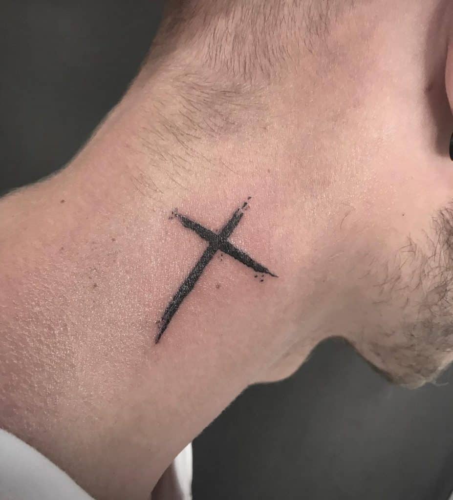 A simple black cross tattoo on the side of a person's neck