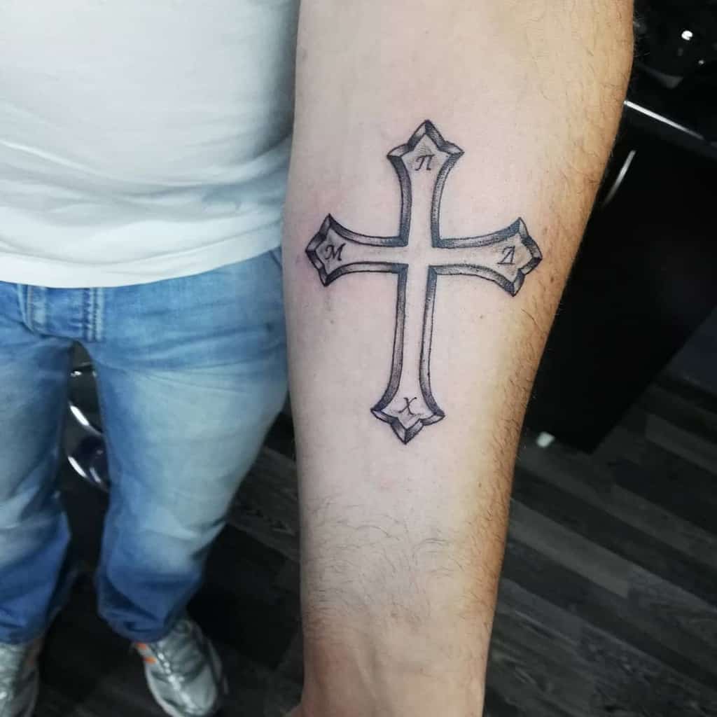 Forearm tattoo of a cross with Greek letters at each point