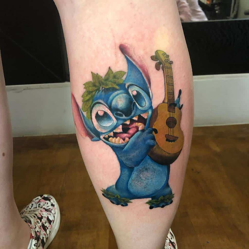 A vibrant tattoo of Stitch from Lilo & Stitch wearing a leaf crown and holding a ukulele, designed with bright colors and a playful expression