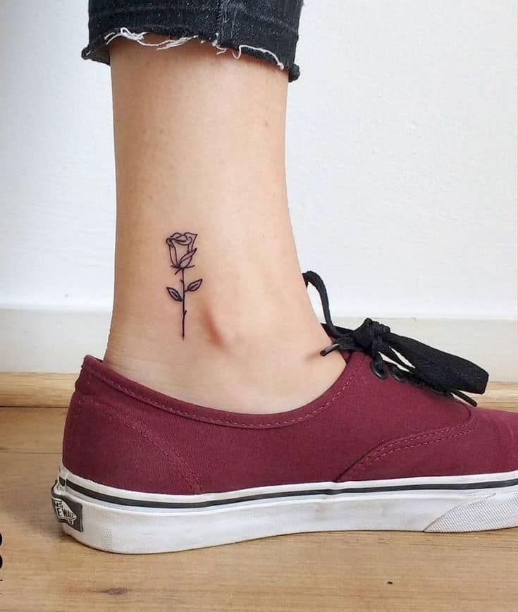 Minimalist fine-line tattoo of a single rose on the ankle, symbolizing the enchanted rose from Beauty and the Beast.
