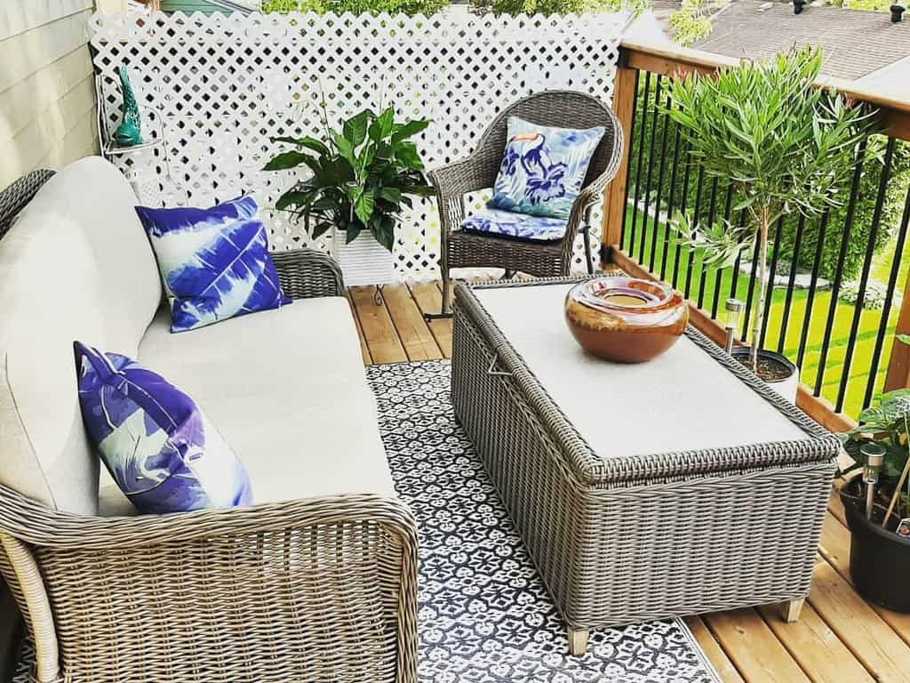 small wood deck wicker furniture plants rug