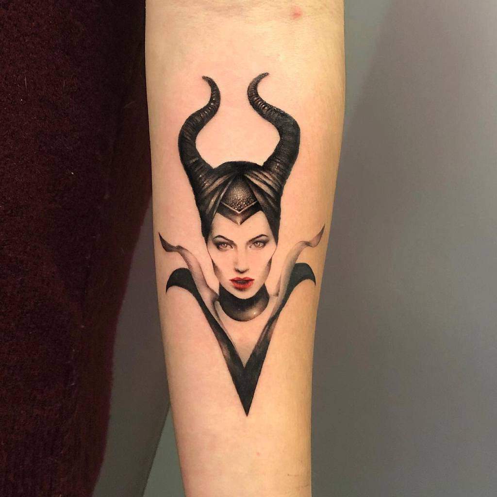 A detailed and realistic tattoo of Maleficent, showcasing her iconic horns and regal appearance, elegantly placed on the forearm