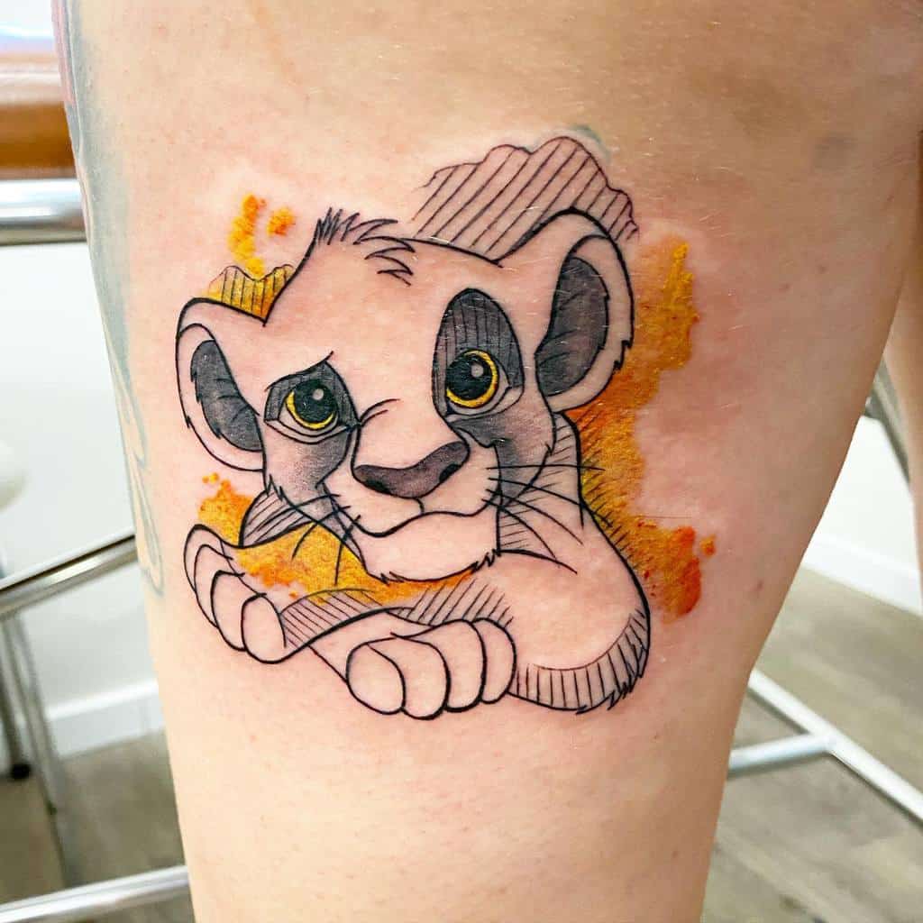 This tattoo portrays a playful and detailed design of young Simba, capturing his curiosity and innocence with soft, bright color accents around him