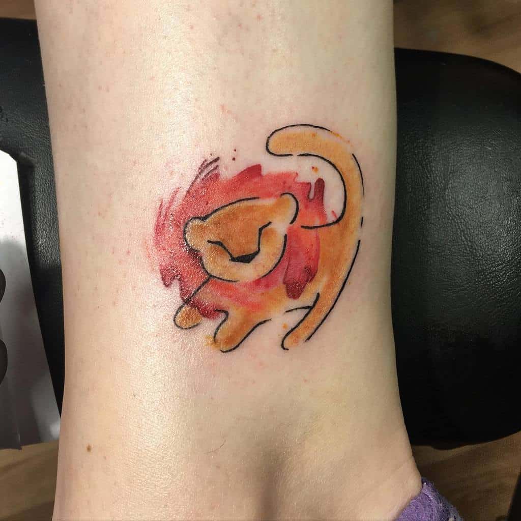 A vibrant tattoo of a playful lion silhouette with a watercolor effect, capturing the spirit of Simba's youthful energy