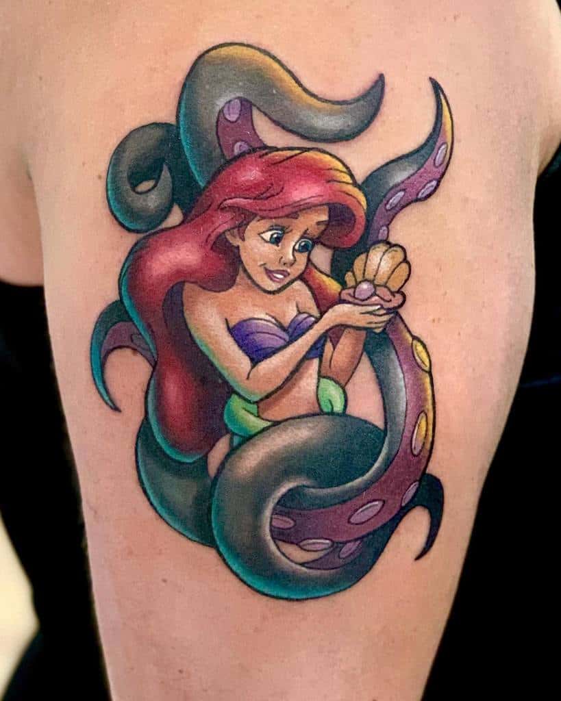 A colorful tattoo of Ariel, the Little Mermaid, holding a shell while entangled with Ursula's tentacles, capturing an iconic moment from the film