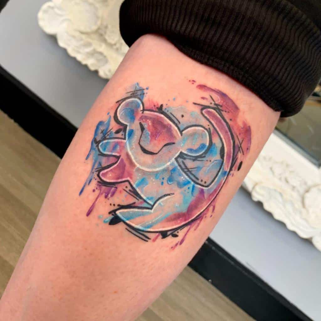 A watercolor tattoo of Simba from The Lion King, with vibrant blues and pinks accentuating his playful spirit
