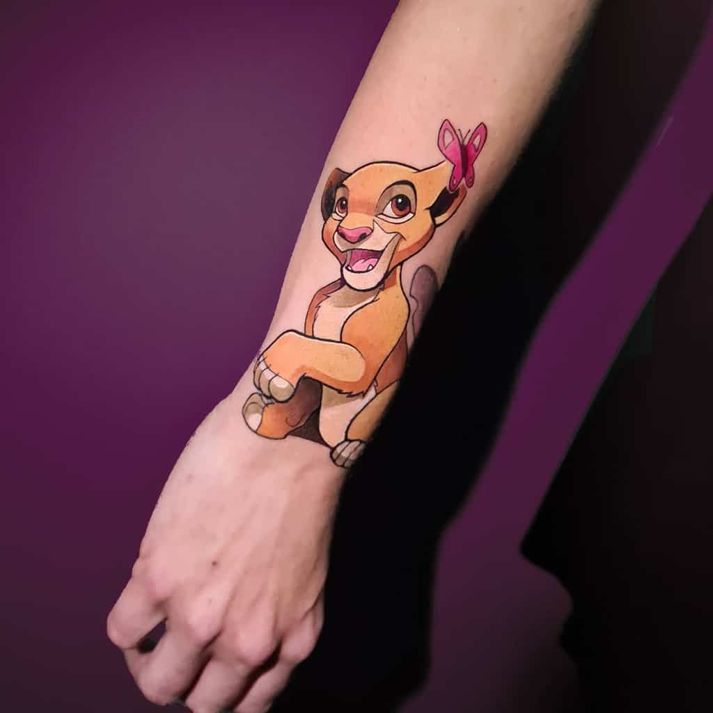 A vibrant, playful tattoo of young Simba from The Lion King, complete with a cute butterfly accent