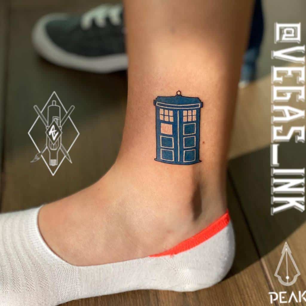 Doctor Who tattoo depicting a stylized TARDIS in bold blue with precise black outlines