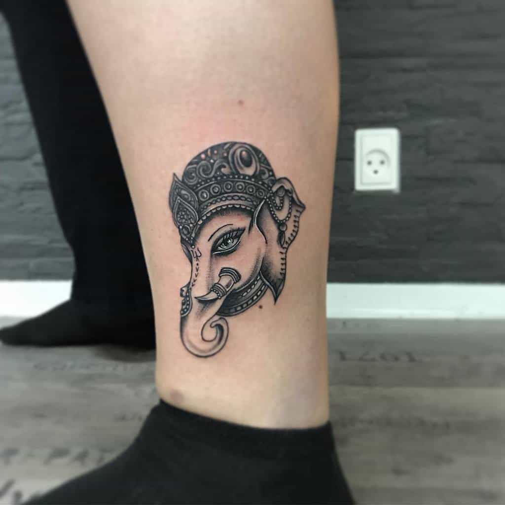 Leg tattoo of an ornate elephant head, representing Ganesha
