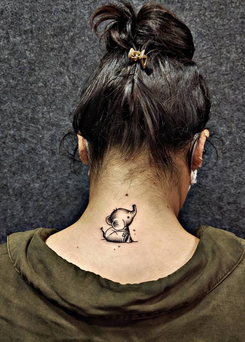 Minimalistic elephant tattoo on the back of the neck, showcasing a cute sitting design with fine black ink details