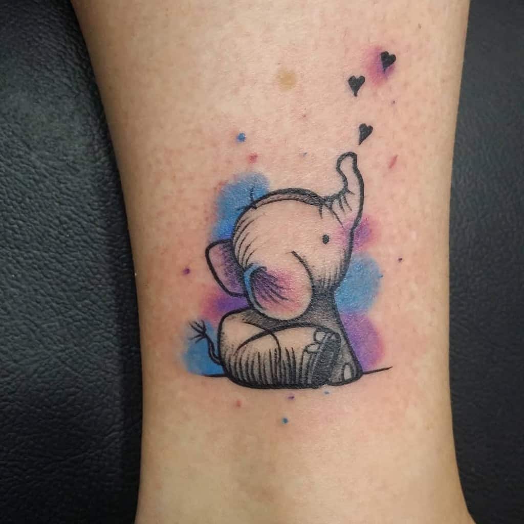 A cute elephant tattoo with colorful watercolor splashes and small hearts