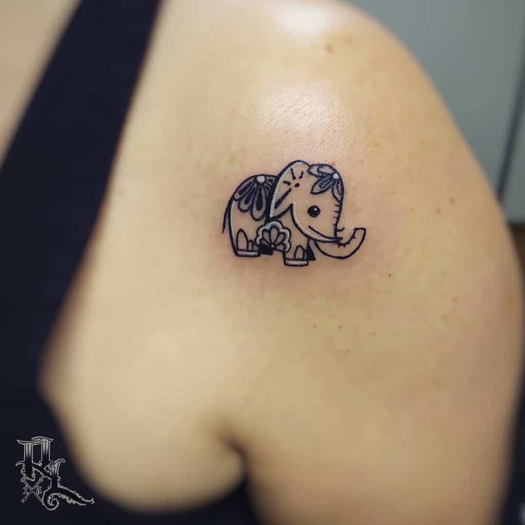 Tattoo of a small, decorative elephant on an upper shoulder