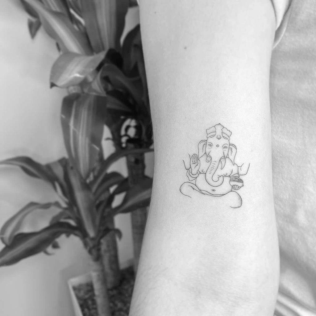 A small tattoo of Ganesha on an arm