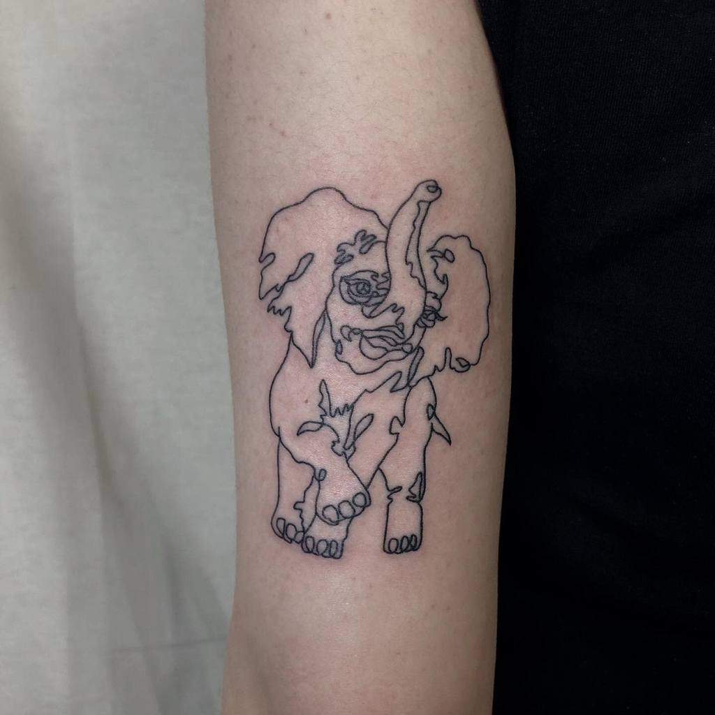 A line drawing tattoo of an abstract elephant on an arm