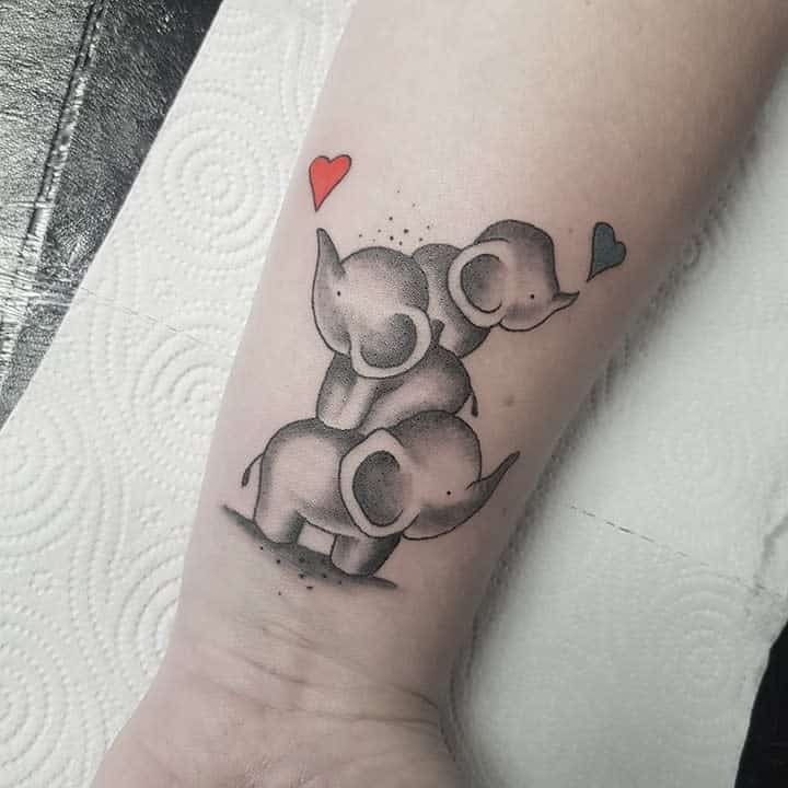 Tattoo of three elephants stacked on each other with a red heart and a blue heart above them