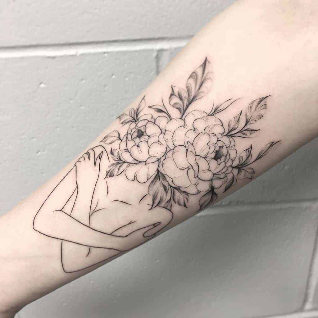 Tattoo of a figure with a peony flower head and crossed arms on an inner forearm