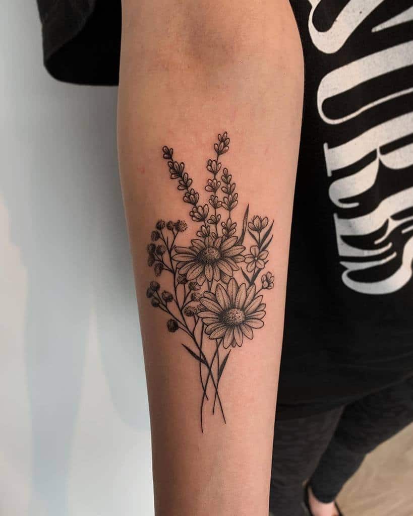 Tattoo of delicate flowers and leaves on a forearm